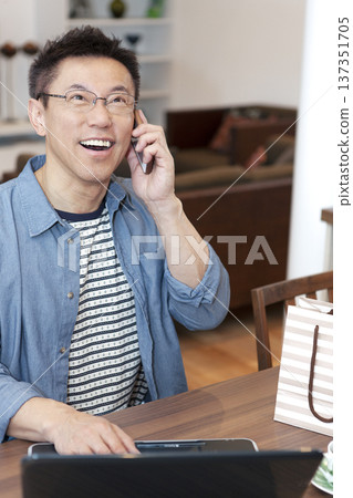 Middle-aged man operating a laptop Middle-aged man operating a laptop 137351705