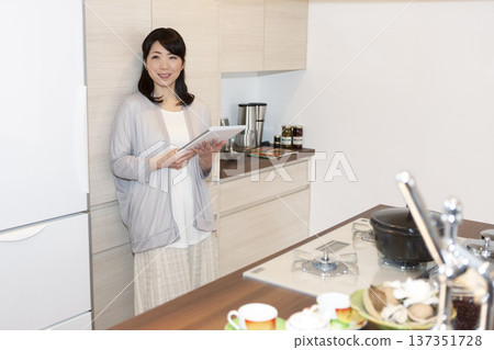 Middle-aged woman holding a tablet PC Middle-aged woman holding a tablet PC 137351728