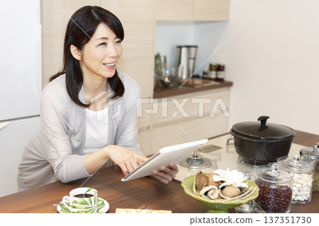Middle-aged woman holding a tablet PC Middle-aged woman holding a tablet PC 137351730