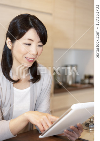 Middle-aged woman holding a tablet PC Middle-aged woman holding a tablet PC 137351733