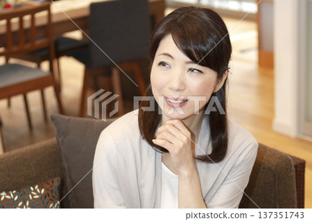 Middle aged woman sitting on the sofa Middle aged woman sitting on the sofa 137351743