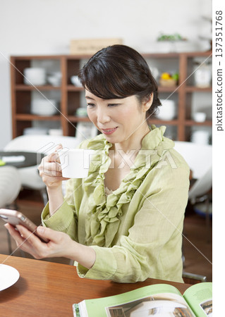 A middle-aged woman sitting at a counter in a cafe A middle-aged woman sitting at a counter in a cafe 137351768