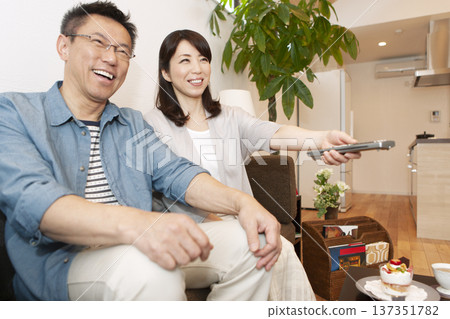 Middle-aged couple watching TV Middle-aged couple watching TV 137351782
