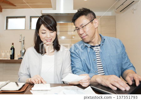 A middle-aged couple creating a household account book A middle-aged couple creating a household account book 137351793