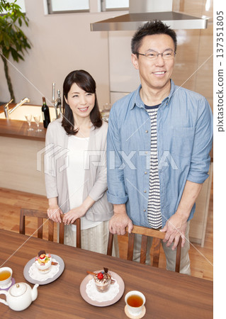 一對中年夫婦站在一張桌子前。 137351805