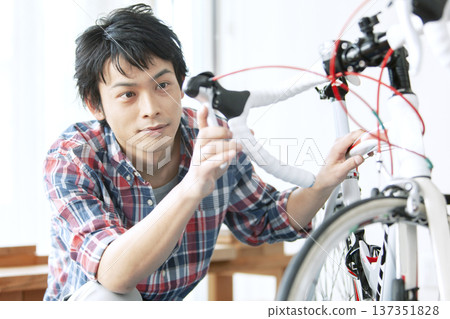 A man servicing a bicycle 137351828