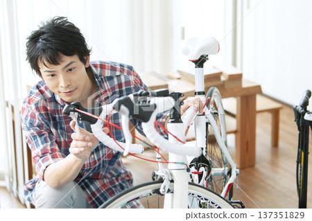 A man servicing a bicycle A man servicing a bicycle 137351829