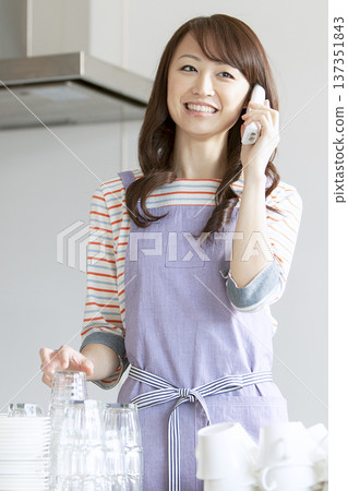 Cafe staff making a phone call Cafe staff making a phone call 137351843