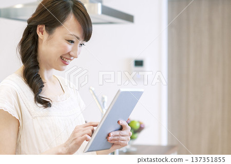 A woman who operates a tablet PC A woman who operates a tablet PC 137351855