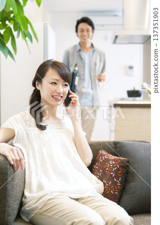 Couple talking on the phone on the sofa Couple talking on the phone on the sofa 137351903
