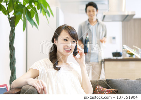 Couple talking on the phone on the sofa 137351904