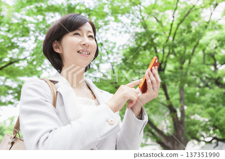 A career woman operating a mobile phone A career woman operating a mobile phone 137351990