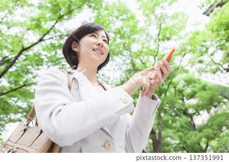 一位職業婦女正在操作手機 137351991