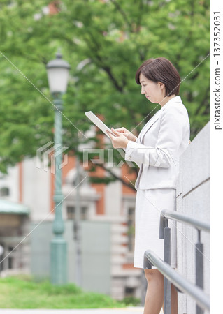 A career woman operating a tablet A career woman operating a tablet 137352031