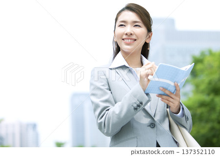 Business woman with a notebook Business woman with a notebook 137352110