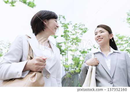 Two businesswomen walking in an office district 137352160