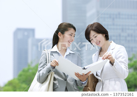 Two businesswomen looking at documents Two businesswomen looking at documents 137352161