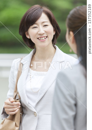 Two businesswomen having a conversation while standing 137352189