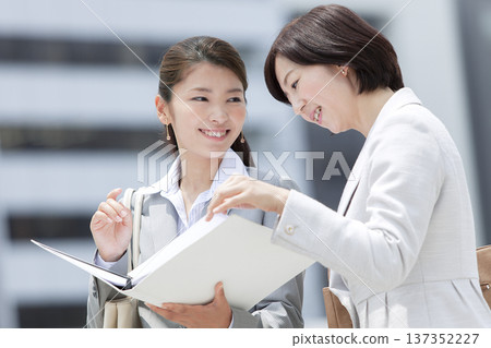 Two businesswomen looking at documents Two businesswomen looking at documents 137352227