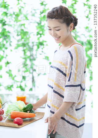 Woman drinking juice in the kitchen Woman drinking juice in the kitchen 137352240