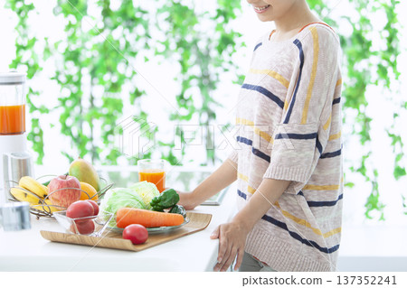 Woman drinking juice in the kitchen Woman drinking juice in the kitchen 137352241