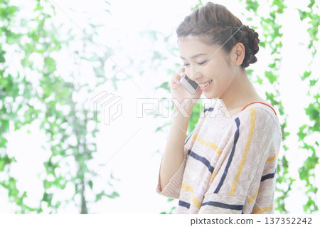Woman making a phone call on a smartphone Woman making a phone call on a smartphone 137352242