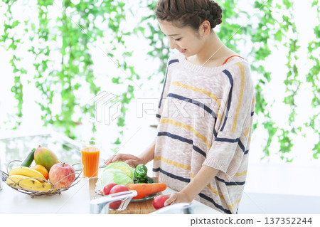 A smiling woman standing in the kitchen A smiling woman standing in the kitchen 137352244