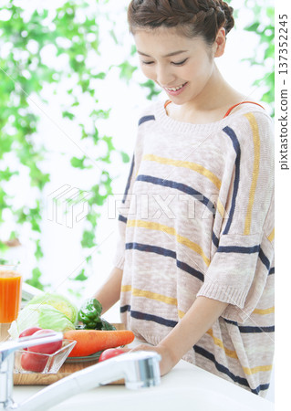 A smiling woman standing in the kitchen 137352245