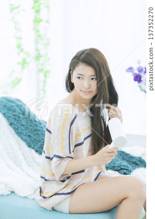 婦女用吹風機烘乾她的頭髮。 137352270