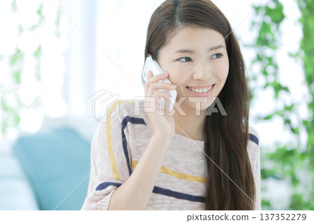 一個女人在沙發上打電話 137352279