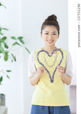 A woman holding a heart-shaped object 137352296
