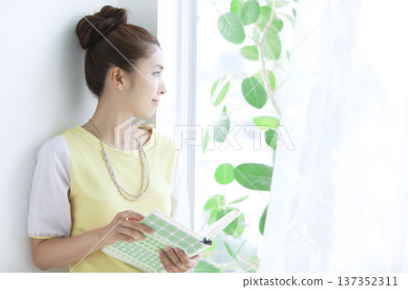 A woman reading with a window 137352311