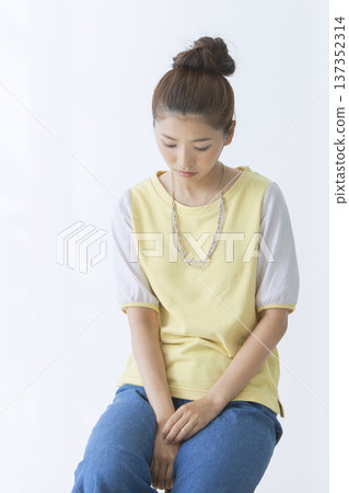 一個女人坐在椅子上思考 137352314