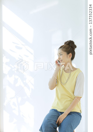 一名女子坐在椅子上打電話 137352334