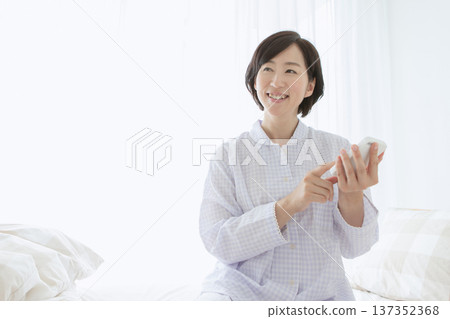 Woman operating a smartphone in bed 137352368