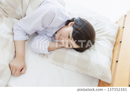 Middle-aged woman sleeping in bed 137352381