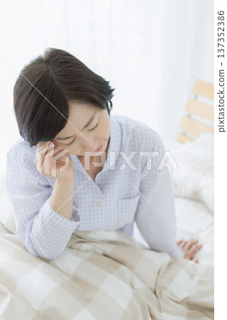 Middle-aged woman sitting in bed 137352386