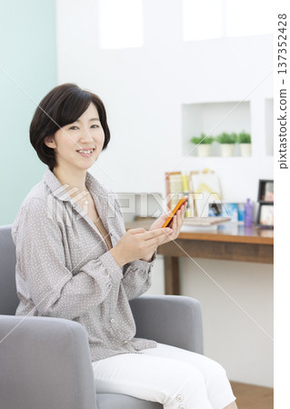 操作智能手機的中年婦女 137352428