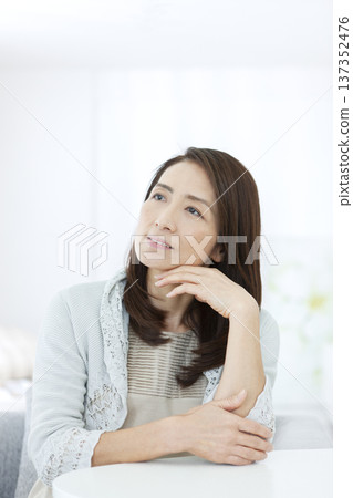 一位老婦人坐在椅子上沉思 137352476