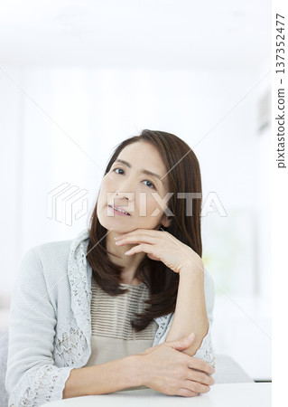 Senior woman sitting in a chair and thinking Senior woman sitting in a chair and thinking 137352477