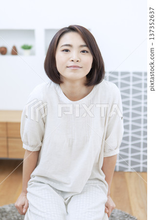 一位女士坐在客廳的椅子上 137352637