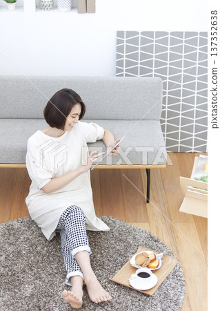 女人在客廳裡操作平板電腦 137352638