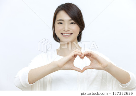 A woman who makes a heart by hand A woman who makes a heart by hand 137352659