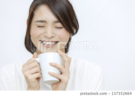 Smiling woman holding a teacup 137352664