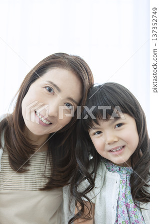 Smiling grandmother and grandchild standing close together Smiling grandmother and grandchild standing close together 137352749