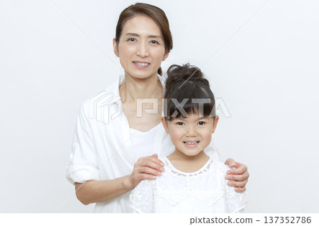 Smiling grandmother and grandchild standing close together Smiling grandmother and grandchild standing close together 137352786