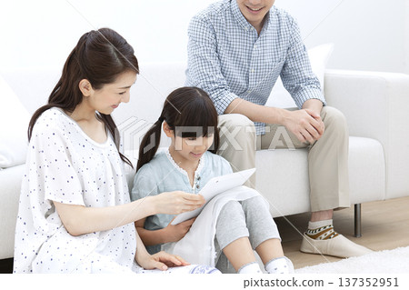 Family operating a tablet in the living room Family operating a tablet in the living room 137352951