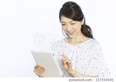 A woman who operates a tablet A woman who operates a tablet 137353030