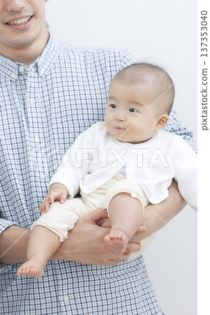 A father holding a baby 137353040