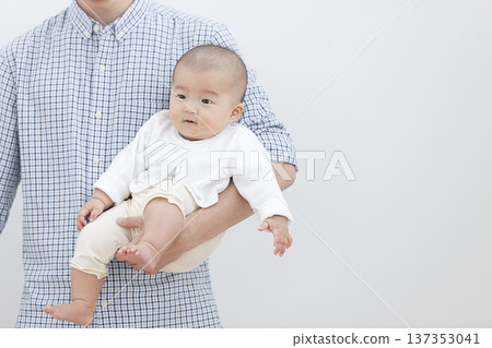 A father holding a baby 137353041